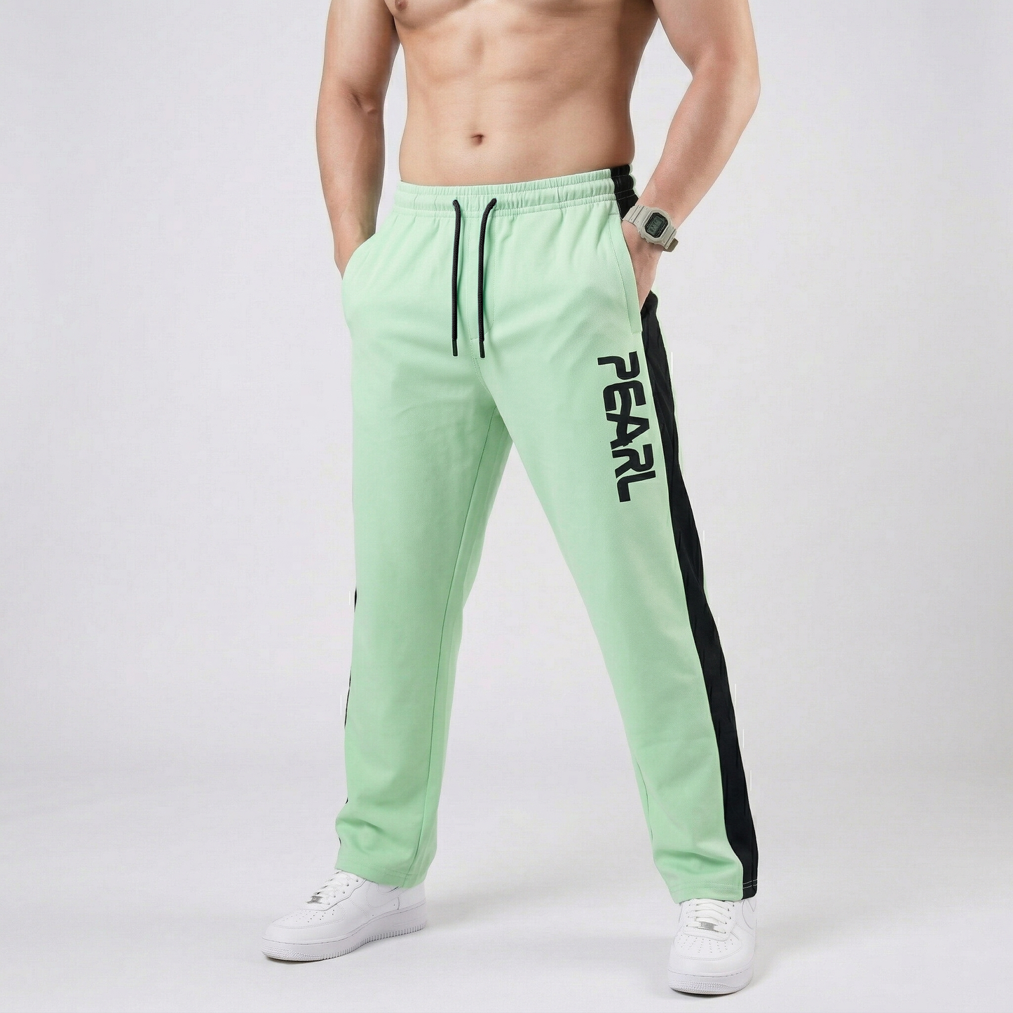 Mint green athletic pants with black Pearl branding - Front view